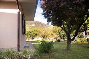 a building with a tree and a hill in the background at Casa Camilla in Rancio Valcuvia