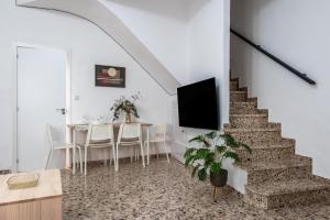 a living room with a staircase with a table and a tv at Santa Clara Home in Marchena