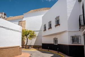 a white building with windows and a tree at Santa Clara Home in Marchena
