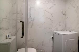 アルマカオ・デ・ペラにあるSunshine Apartmentのトイレとシャワー付きの白いバスルーム +15枚の写真