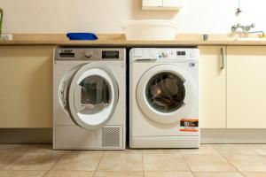 キアンチャーノ・テルメにあるCountry House Podere I Pratiの洗濯機2台、キッチン内のシンク