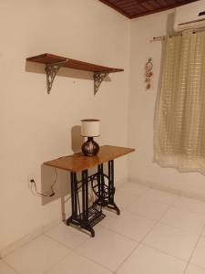 a small table in a room with a lamp on it at Quarto para COP30 in Ananindeua