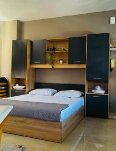 Un dormitorio con una cama con cabecero de madera. en Downtown Comfy Studio 31, en Serres