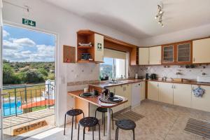 een keuken met een tafel en stoelen en een balkon bij Horta Teresa in Quarteira