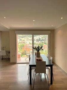a dining room with a table with a vase of flowers at Apartamento Góngora Congresos in Granada