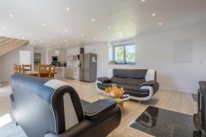 a living room with two chairs and a couch at Chez Lili et André in Meslan