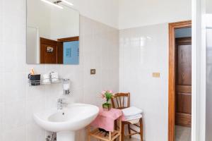 Un baño blanco con lavabo y espejo. en Agriturismo Tramonto in Maremma, en Grosseto