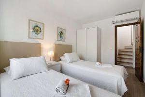 two white beds in a room with a staircase at Apartamento Old Village T2 Duplex in Quarteira +18 photos