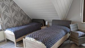 NordwaldeにあるHaus Münsterlandのベッドルーム1室(ベッド2台、椅子付)