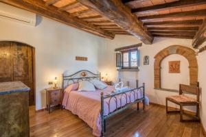 Casale Rosennano - Padronale في Rosennano: غرفة نوم مع سرير وأرضية خشبية