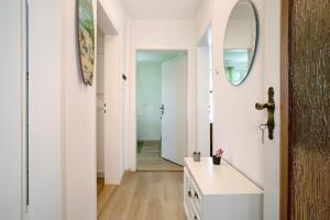 a hallway with a vanity and a mirror at Haus Rosi in Friedrichshafen +13 photos