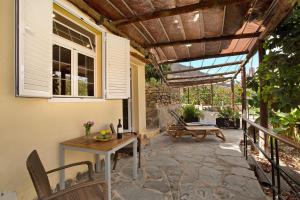 eine Terrasse mit einem Holztisch und einer Bank in der Unterkunft El Granero Paraiso del Molinero in Mogán