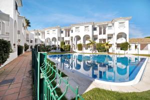 a swimming pool in front of a building at Apartamento Calas Sancti Petri in Novo Sancti Petri