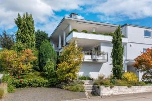 a white house with trees in front of it at Die Ferienwohnung in Bad Bellingen
