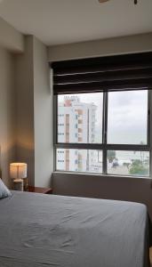 a bedroom with a bed and a large window at Departamento excelente vista y ubicación en Tonsupa in Tonsupa