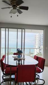 a dining room with a table and chairs and a large window at Departamento excelente vista y ubicación en Tonsupa in Tonsupa