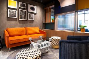 a living room with an orange couch and a table at Holiday Inn Derby Riverlights by IHG in Derby