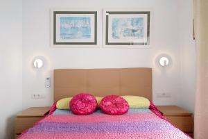 ein Bett mit zwei roten Kissen darauf in der Unterkunft Casa Maylin in Playa Blanca