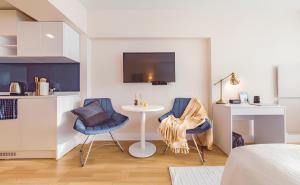 a room with two chairs and a table and a kitchen at Vibrant & Modern ORBi CiTY Apart-Hotel in Batumi +182 photos