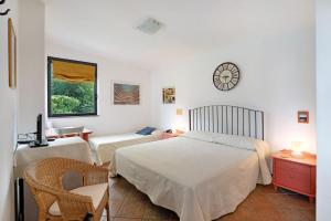 a bedroom with two beds and a clock on the wall at Flegrea House in Pozzuoli +29 photos
