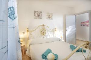 a bedroom with a white bed with towels on it at Su Giuali in SantʼAnna Arresi