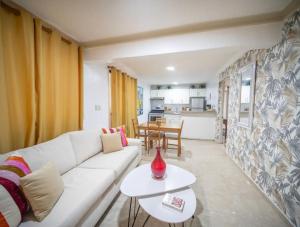 un salon avec un canapé blanc et une table dans l'établissement Stylish 1r-1b Apt Near The Beach And Main Street, à Sosúa