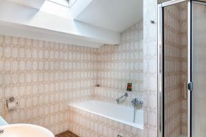 une salle de bain avec une baignoire et un lavabo dans l'établissement Ferienwohnung Bergblick, à Unterammergau 27 autres photos