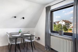 Un comedor con una mesa y una ventana. en Ferienwohnung en Verde, en Felsberg