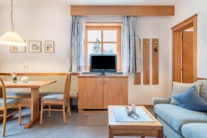 a living room with a couch and a tv at Taufner Apartement C 103 in Parcines