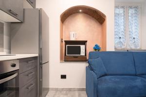 Una sala de estar con un sofá azul y un televisor en Nido Cicogna, en Bisuschio