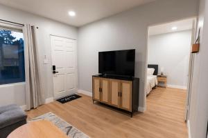 sala de estar con TV de pantalla plana y cama en North Park Getaway, en San Diego