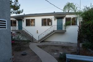 una casa blanca con puertas y escaleras azules en North Park Getaway, en San Diego