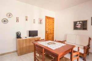 a living room with a table and a television at Appartamento Piano terra in Sarroch