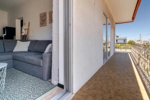 a living room with a couch and a balcony at Casa dos Pirulitos in Apúlia