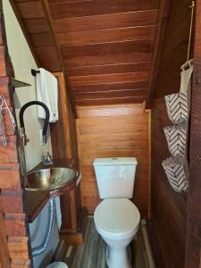 a small bathroom with a toilet and a sink at Casa chalé in Itajaí +76 photos