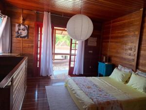 a bedroom with a bed and a large window at Casa chalé in Itajaí