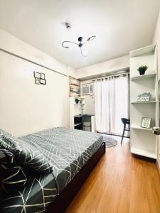 a bedroom with a bed and a desk in it at Camella Northpoint Spacious 3rd Floor Unit in Davao City