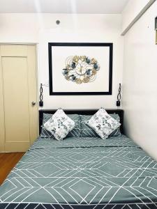 a bedroom with a bed with a picture on the wall at Camella Northpoint Spacious 3rd Floor Unit in Davao City +1 photo