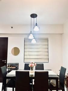 a dining room with a table and chairs and two lights at Camella Northpoint Spacious 3rd Floor Unit in Davao City