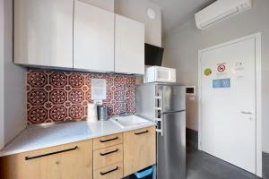 Una cocina con gabinetes blancos y un refrigerador. en Victoria Apartments Fil Rouge, en Diano Marina 12 fotos más