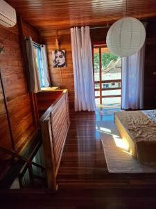 a bedroom with a bed and a window and a lamp at Casa chalé in Itajaí