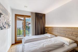 a bedroom with two beds and a large window at Villa Kriendl Nr 3 Piz da Peres in Valdaora