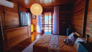 a bedroom with a bed in a room with wooden walls at Casa chalé in Itajaí
