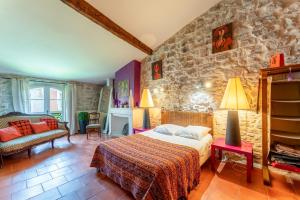 エーグ・モルトにあるLa Maison Dans Les Rempartsのベッドと石の壁のある寝室