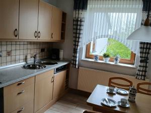 Diemelstadt にあるFerienwohnung Tannenbergのキッチン(シンク、テーブル付)、窓が備わります。