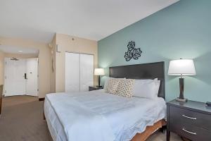 a bedroom with a large white bed and a lamp at Stylish King Apt w Arcade Game & BBQ Near Disney in Orlando