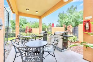 a patio with tables and chairs and a grill at Stylish King Apt w Arcade Game & BBQ Near Disney in Orlando