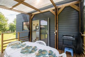 a screened in porch with a table and chairs at Tiny House in Saint-Cernin-de-lʼHerm