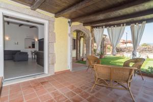 Elle offre une vue sur le patio doté de chaises et d'une table. dans l'établissement Villa Marisa, à Budoni