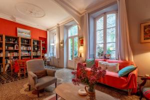 a living room with a red couch and windows at Maison Massenet in Lapalme